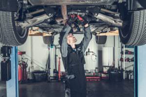 auto mechanic fixing a car in a hot garage